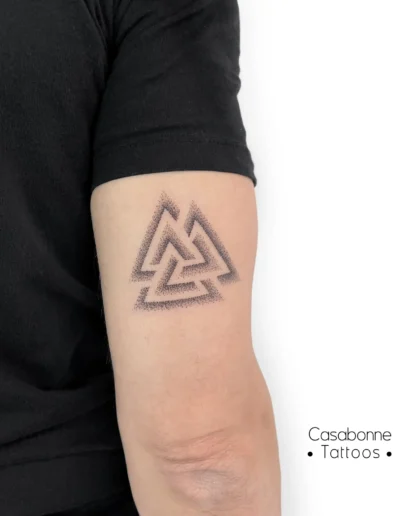 Tatouage d'un valknut (symbole viking), sur le bras, à Toulouse